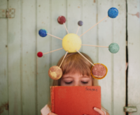 Girl playing with crafted solar system