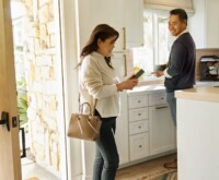 Man looking at a lady with a phone in kitchen