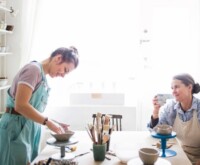 Two females talking over pottery making