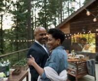 Couple celebrating anniversary on a the deck of a wooden cottage